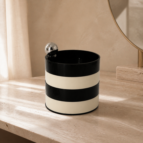 Boîte de rangement rotative noir et ivoire dans un décor en travertin