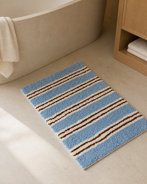 Tapis de bain rétro à rayures bleues dans une salle de bain aux tons naturels